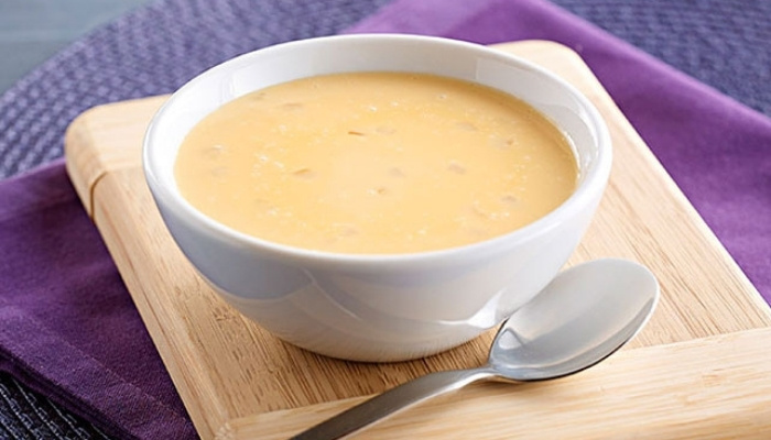 A bowl of creamy soup on a wooden board—discover more on our Food Menu Dilworth MN.