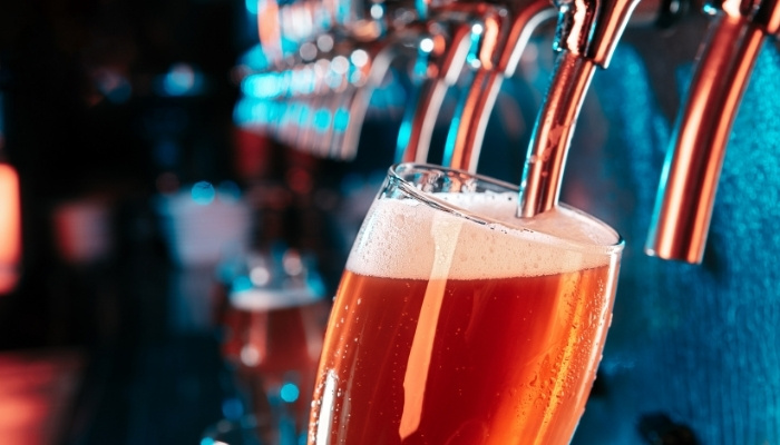 A glass fills with beer at Silver Spike Bar & Grill, Dilworth Minnesota Restaurant taps behind.
