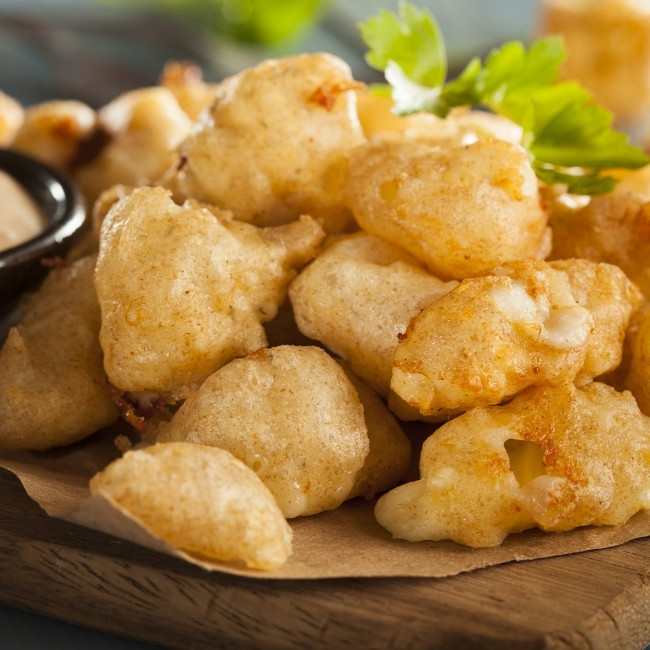 Golden, crispy fried cheese curds served at our Restaurant & Bar in Dilworth MN with parsley garnish.