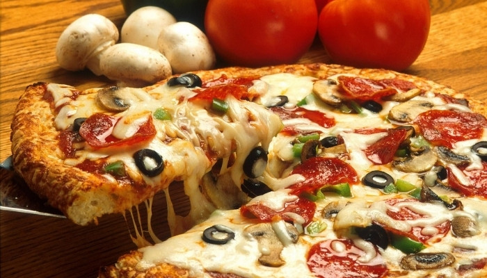 A slice of cheesy pizza served at our Restaurant & Bar in Dilworth MN, loaded with toppings.