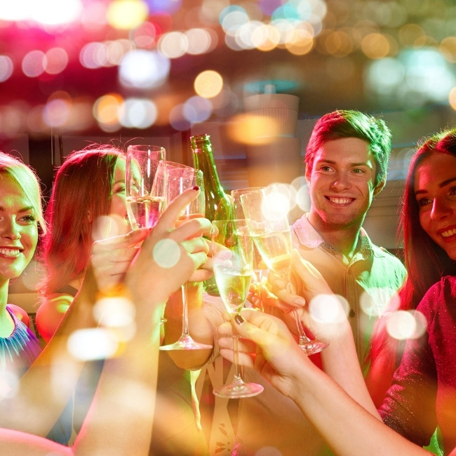 A group enjoying Catering & Private Parties Dilworth MN, smiling and clinking glasses at a party.