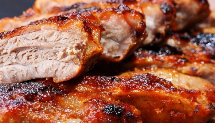 Close-up of juicy, grilled barbecue ribs from the Food Menu Dilworth MN, caramelized and crispy.