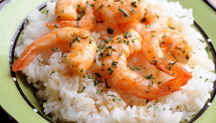 Cooked shrimp with herbs over rice on a green plate at Silver Spike Bar & Grill in Dilworth.